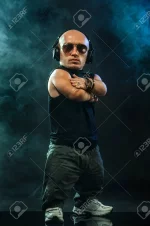 109401464-portrait-of-stylish-midget-mc-in-with-headphones-and-sunglasses-posing-with-microph...webp